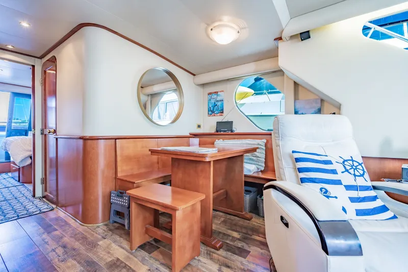 Slide: The Image of Interior of 2003 Bluewater Yachts Custom 6000, featuring wooden dining area and nautical decor. - 29