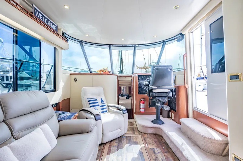 Slide: The Image of Luxurious interior of 2003 Bluewater Yachts Custom 6000 with plush seating and panoramic windows. - 33