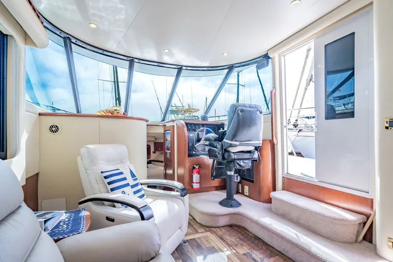 Slide: The Image of Luxurious interior of 2003 Bluewater Yachts Custom 6000 with plush seating and panoramic windows. - 32