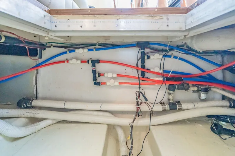 Slide: The Image of Engine room plumbing of 2003 Bluewater Yachts Custom 6000, showcasing pipes and fittings. - 84