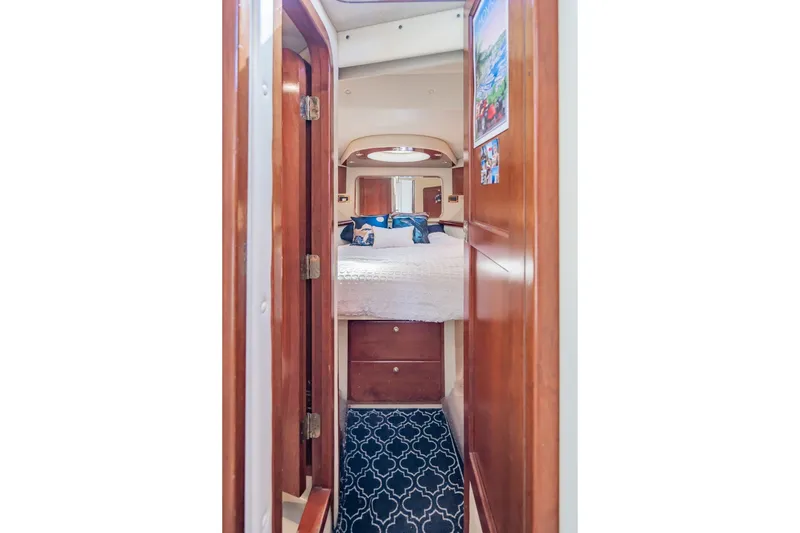 Slide: The Image of Interior cabin of 2003 Bluewater Yachts Custom 6000, featuring cozy bedding and wooden accents. - 57