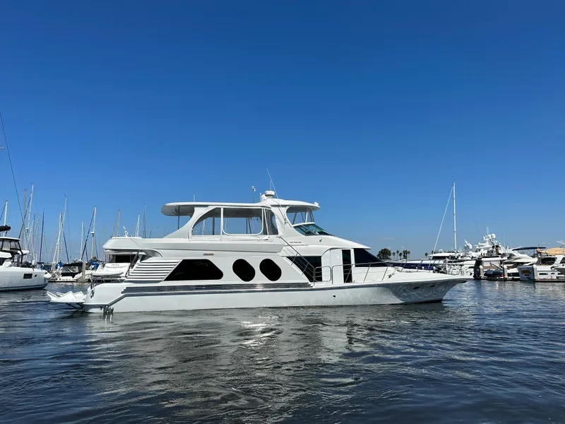 Slide: The Image of A luxurious 2003 Bluewater Yachts Custom 6000 in the harbor, surrounded by other boats. - 1