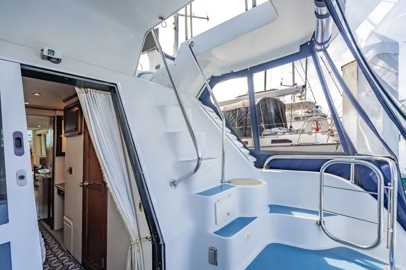 Slide: The Image of 2003 Bluewater Yachts Custom 6000 interior with stairs, open door, and marina view. - 72