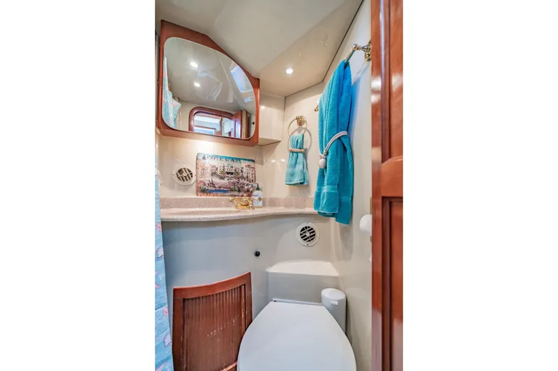 Slide: The Image of Luxurious bathroom in 2003 Bluewater Yachts Custom 6000, featuring elegant fixtures and turquoise towels. - 55