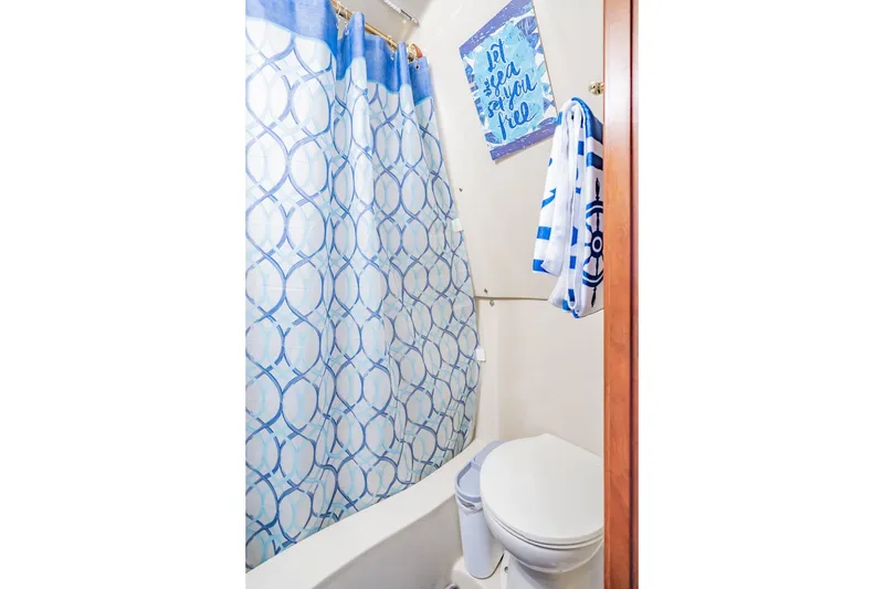 Slide: The Image of Bathroom in 2003 Bluewater Yachts Custom 6000 with nautical decor and blue shower curtain. - 66