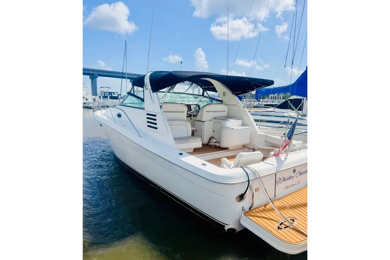 The Image of 1997 Sea Ray 330 Express Cruiser docked at marina under blue sky. - 0