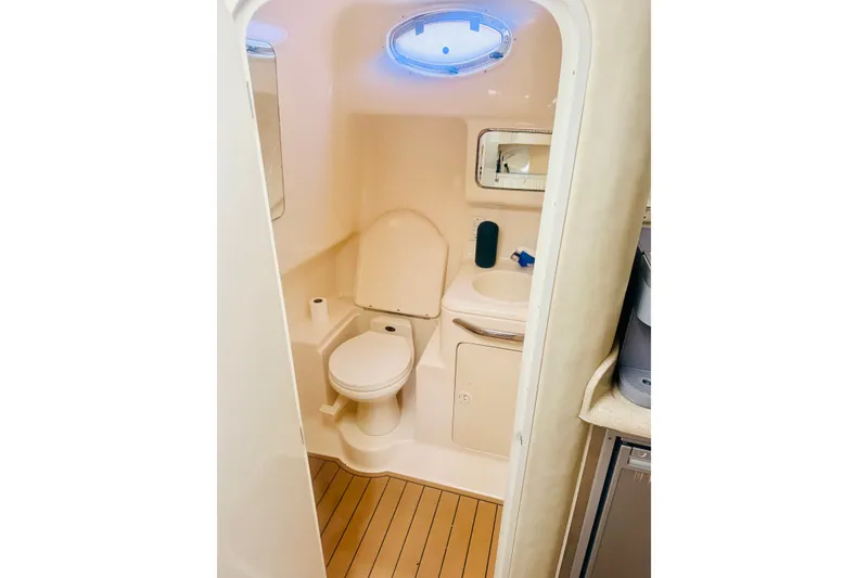 Slide: The Image of 1997 Sea Ray 330 Express Cruiser bathroom with toilet, sink, and porthole window. - 9