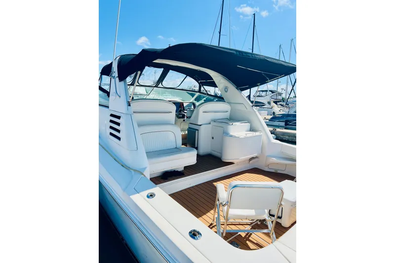 Slide: The Image of 1997 Sea Ray 330 Express Cruiser with spacious deck and seating, docked at marina. - 2