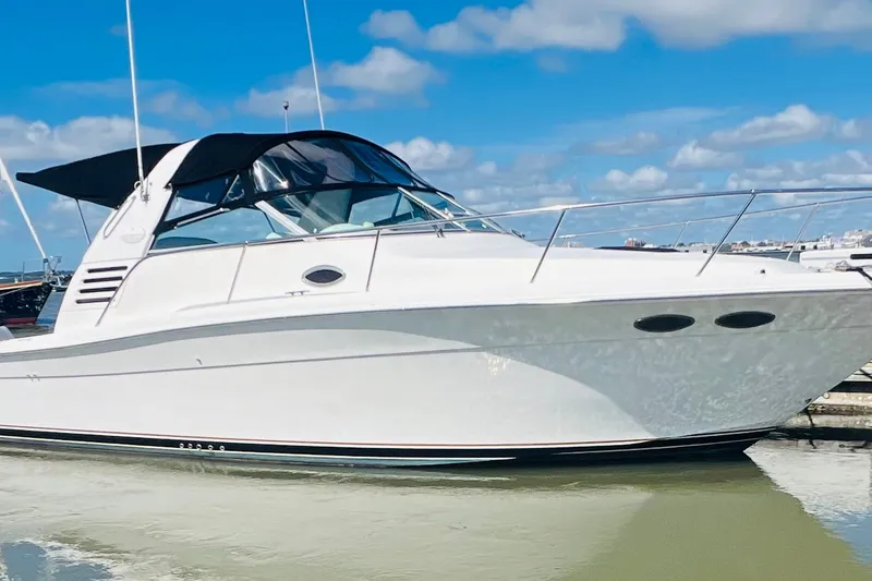 Slide: The Image of 1997 Sea Ray 330 Express Cruiser docked under a clear blue sky. - 10