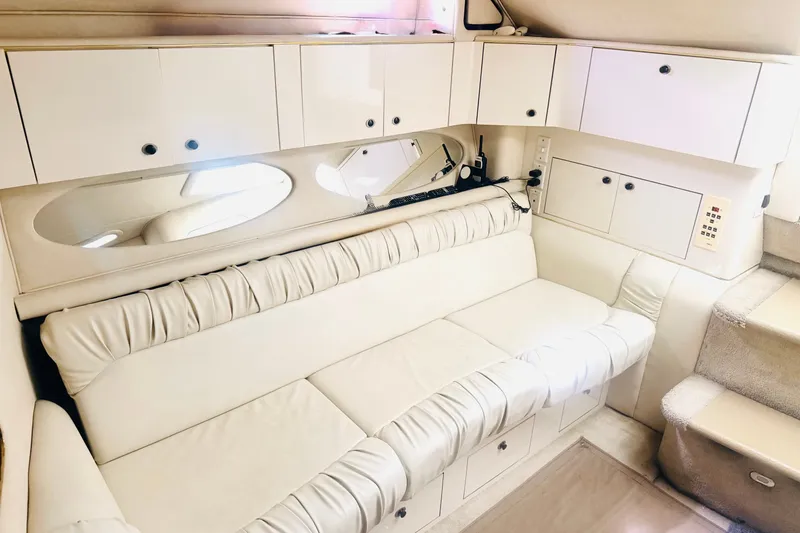 Slide: The Image of Interior of 1997 Sea Ray 330 Express Cruiser with white leather seating and cabinetry. - 6