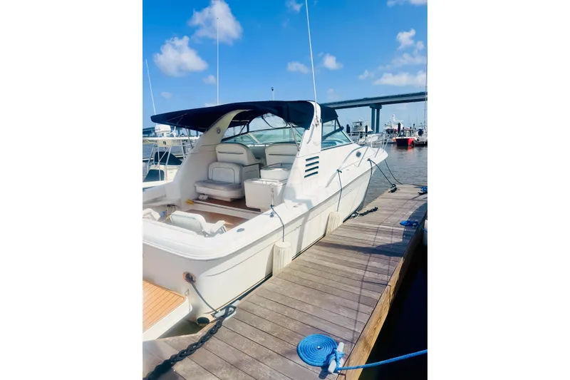 Slide: The Image of 1997 Sea Ray 330 Express Cruiser docked at marina under blue sky. - 1