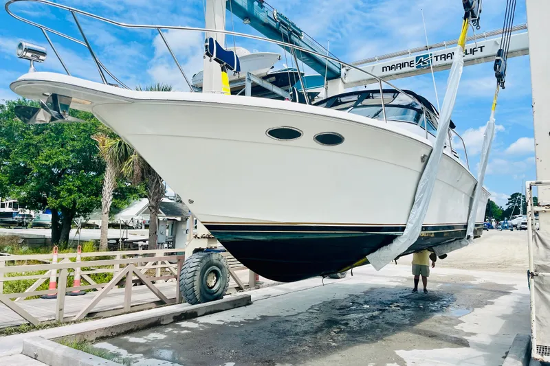 Slide: The Image of 1997 Sea Ray 330 Express Cruiser being lifted by a marine travel lift. - 11