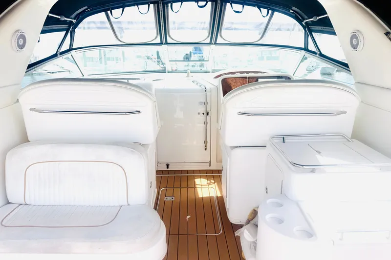 Slide: The Image of Interior of a 1997 Sea Ray 330 Express Cruiser with white seating and wood flooring. - 3