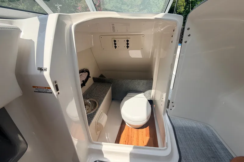 Slide: The Image of 2016 Chaparral 250 Suncoast boat interior with compact bathroom and sink. - 39