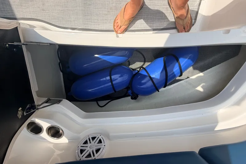 Slide: The Image of Storage compartment with blue fenders on a 2016 Chaparral 250 Suncoast boat. - 41
