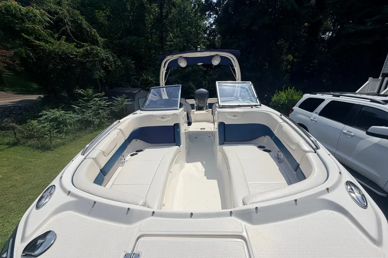 Slide: The Image of 2016 Chaparral 250 Suncoast boat with spacious seating, parked outdoors. - 15