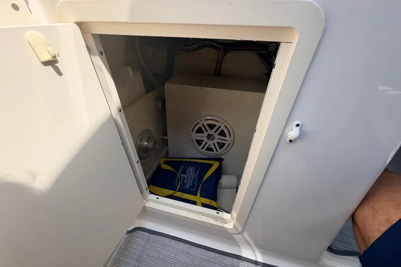 Slide: The Image of Open storage compartment on 2016 Chaparral 250 Suncoast boat with life jacket inside. - 32
