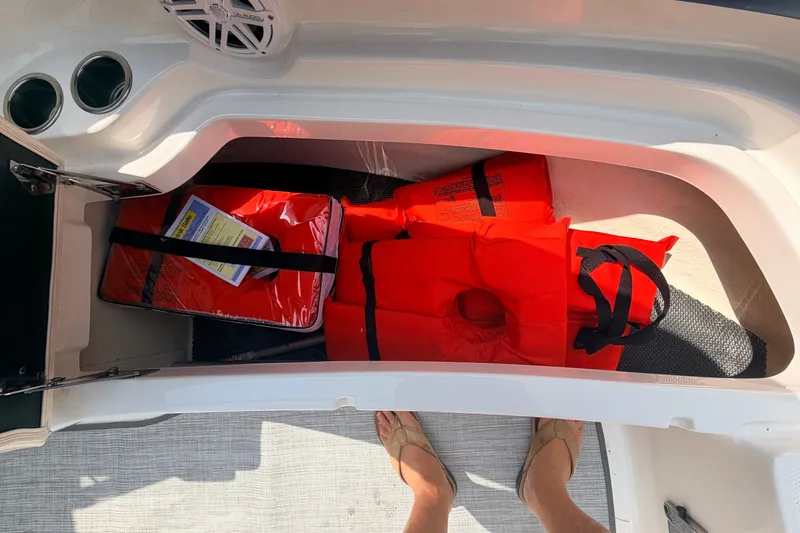 Slide: The Image of Storage compartment in 2016 Chaparral 250 Suncoast boat with life jackets and safety gear. - 40