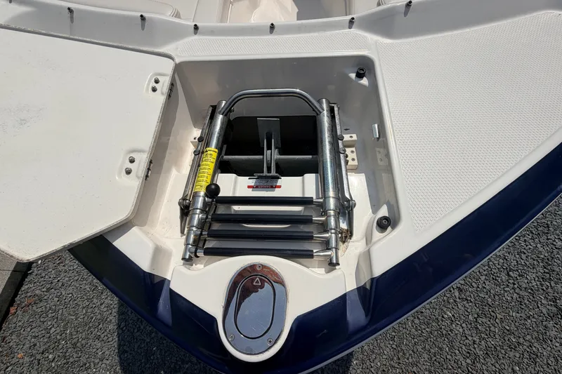 Slide: The Image of 2016 Chaparral 250 Suncoast boat ladder compartment, open with visible ladder and storage. - 45