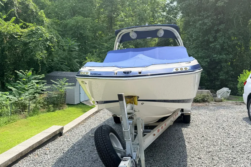 Slide: The Image of 2016 Chaparral 250 Suncoast boat on trailer, surrounded by lush greenery. - 3