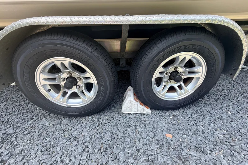 Slide: The Image of Trailer wheels of a 2016 Chaparral 250 Suncoast on gravel with wheel chock. - 36