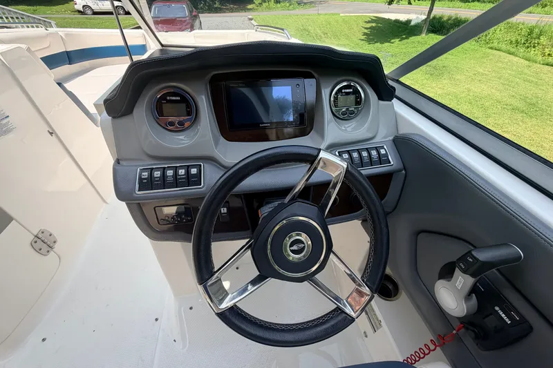 Slide: The Image of 2016 Chaparral 250 Suncoast boat dashboard with steering wheel and control panel. - 25