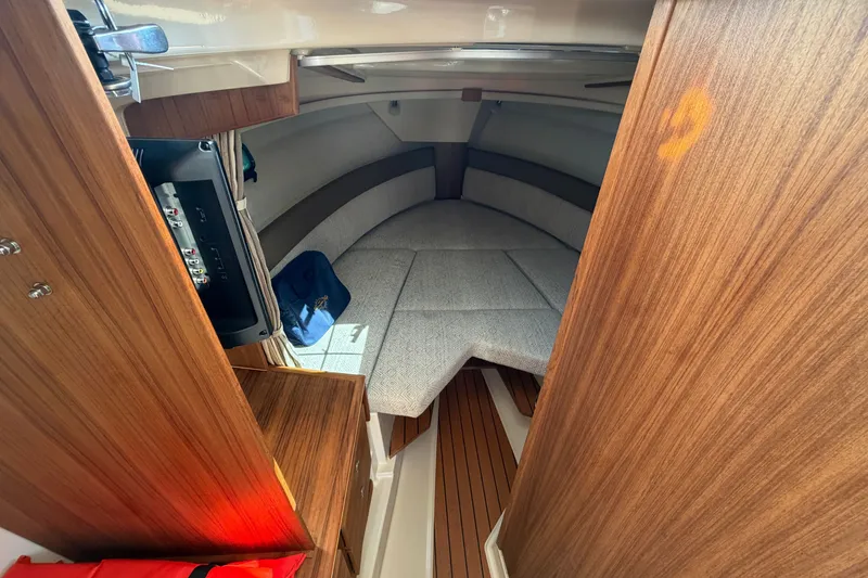 Slide: The Image of Interior cabin of 2025 Ranger Tugs R-27 with wood finish and cozy seating. - 14