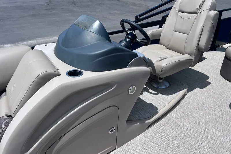 Slide: The Image of Captain's seat and helm of 2020 Regency 250 DL3 pontoon boat, featuring beige upholstery. - 13