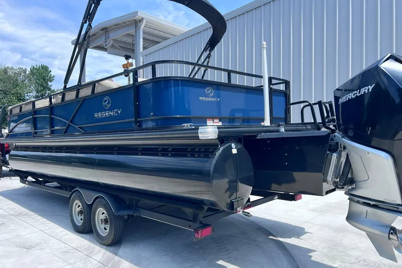 Slide: The Image of 2020 Regency 250 DL3 pontoon boat with Mercury engine, parked outdoors. - 6