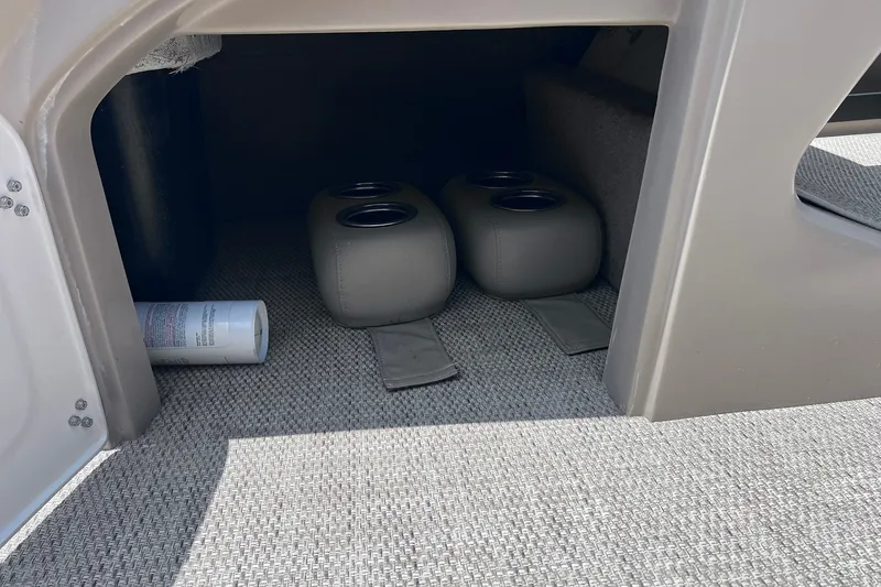 Slide: The Image of Storage compartment in a 2020 Regency 250 DL3 boat with cup holders and carpeted flooring. - 22