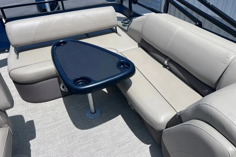 Slide: The Image of 2020 Regency 250 DL3 boat interior with beige seating and a dark table. - 12