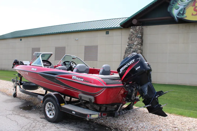 Slide: The Image of Red 2006 Triton 190FS boat with Mercury XR6 engine on a trailer. - 4