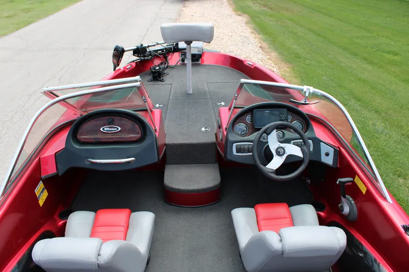 Slide: The Image of 2006 Triton 190FS boat interior with red and gray seating, steering wheel, and dashboard controls. - 5
