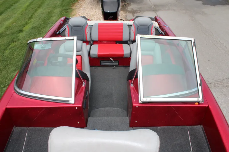 Slide: The Image of 2006 Triton 190FS boat interior with red and gray seating, open windshield, and carpeted floor. - 7