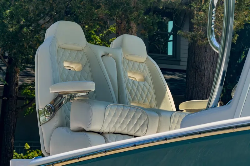 Slide: The Image of Luxurious white leather seats on a 2025 Weaver 25 boat, surrounded by trees. - 1