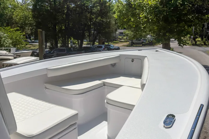 Slide: The Image of Bow seating area of a 2025 Weaver 25 boat, featuring white cushioned seats. - 12