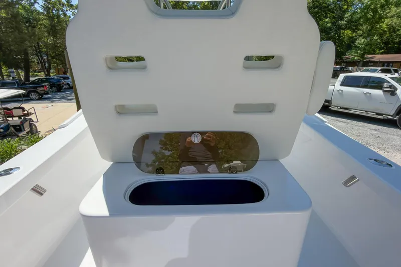 Slide: The Image of 2025 Weaver 25 boat interior with open storage compartment, parked vehicles in background. - 4