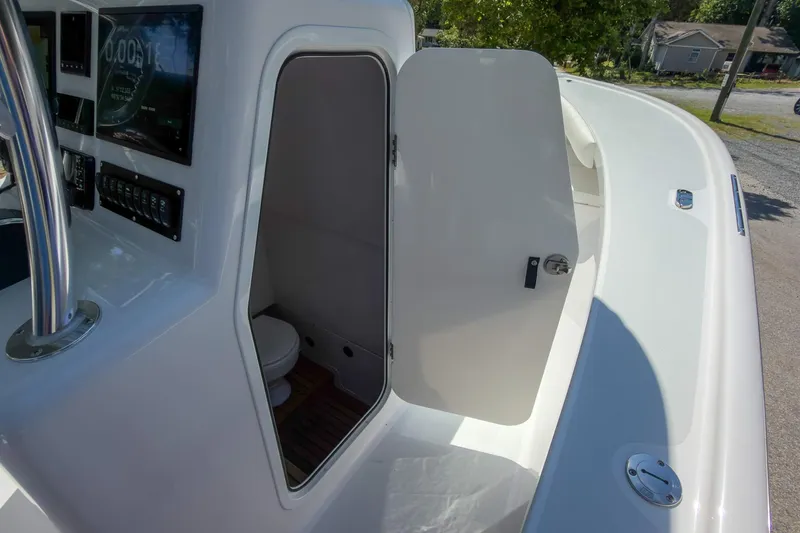 Slide: The Image of 2025 Weaver 25 boat interior with open cabin door and visible controls. - 9
