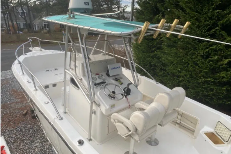Slide: The Image of 2001 Sea Pro 235 Center Console boat with helm and seating, docked outdoors. - 30