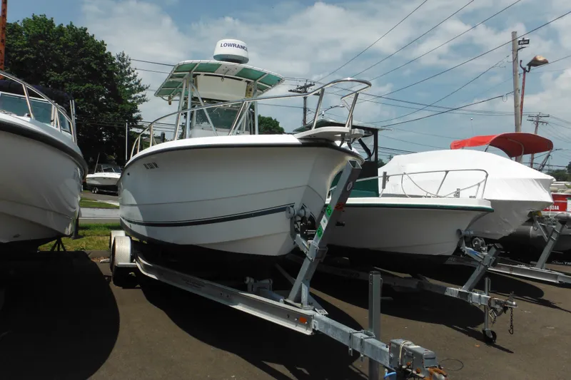 Slide: The Image of 2001 Sea Pro 235 Center Console boat on trailer, parked outdoors. - 2