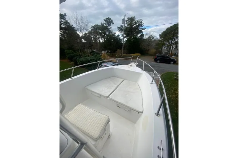 Slide: The Image of 2001 Sea Pro 235 Center Console boat with cushioned seating, parked outdoors. - 31