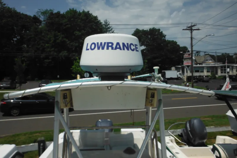 Slide: The Image of 2001 Sea Pro 235 Center Console with Lowrance radar on top, parked near a road. - 26
