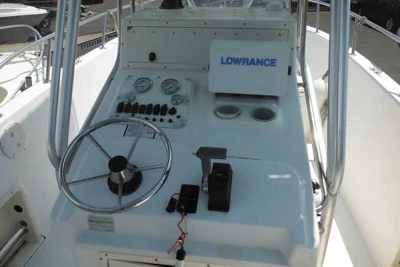 Slide: The Image of 2001 Sea Pro 235 Center Console boat dashboard with steering wheel and Lowrance equipment. - 9