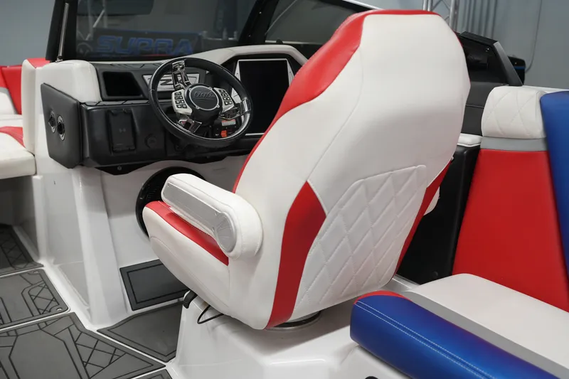 Slide: The Image of 2021 Tigé 25ZX boat interior with red, white, and blue seating and steering wheel. - 17