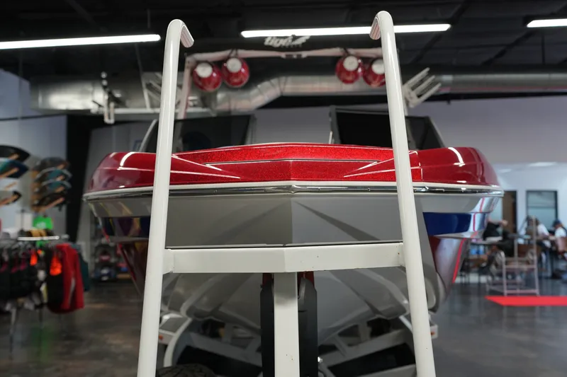 Slide: The Image of 2021 Tigé 25ZX boat displayed indoors, showcasing its sleek red and white design. - 8