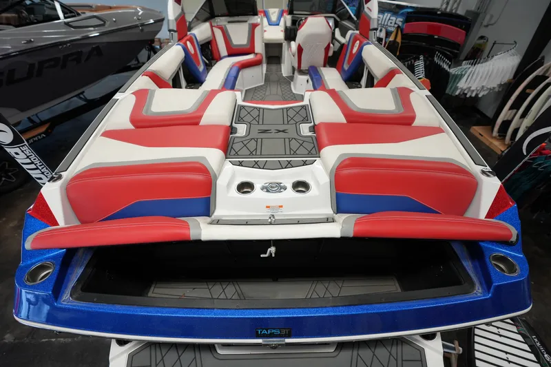 Slide: The Image of 2021 Tigé 25ZX boat interior with red, white, and blue seating. - 12