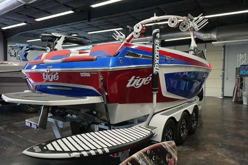 Slide: The Image of 2021 Tigé 25ZX boat in showroom, featuring vibrant red and blue design. - 5