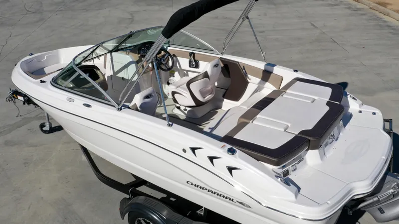 Slide: The Image of A white 2020 Chaparral 19 SSi boat with brown seats and a black bimini top. - 3