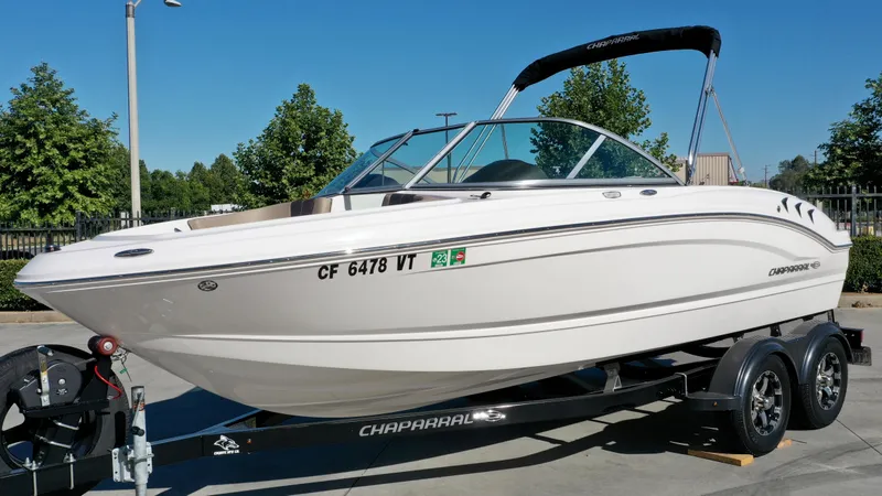 Slide: The Image of A white 2020 Chaparral 19 SSi boat on a trailer, featuring a black bimini top. - 5