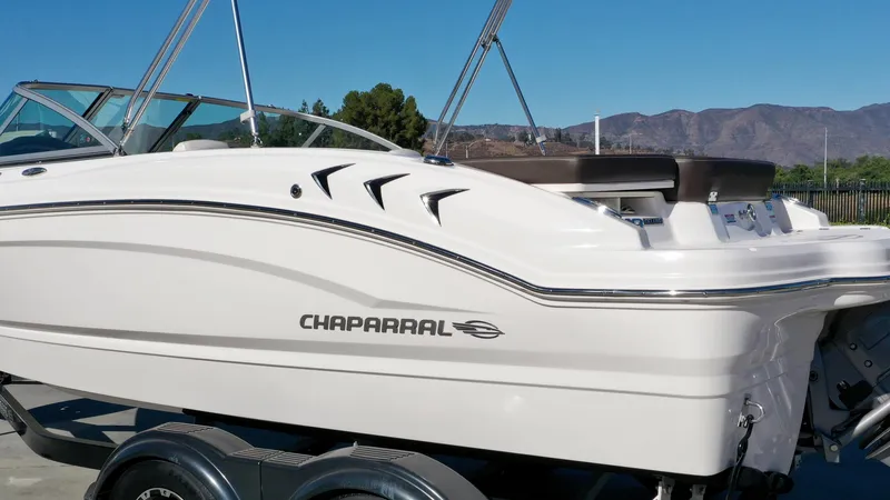 Slide: The Image of A white 2020 Chaparral 19 SSi boat on a trailer, set against a mountain backdrop. - 4